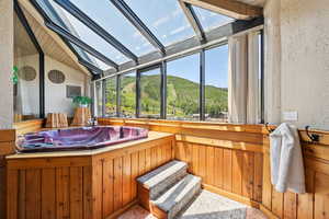 Bathroom with vaulted ceiling, a textured wall, and wooden walls