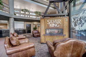 Living room featuring a high ceiling, carpet floors, and a fireplace