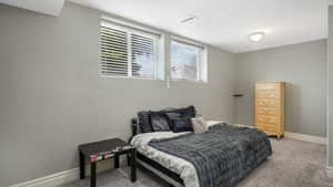 Bedroom featuring light colored carpet and baseboards