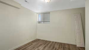 Unfurnished room with wood finished floors and baseboards