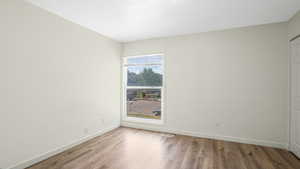 Unfurnished room with wood finished floors and baseboards