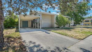View of home's exterior featuring concrete driveway and a lawn