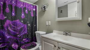 Full bath with vanity, a textured wall, and a shower with curtain