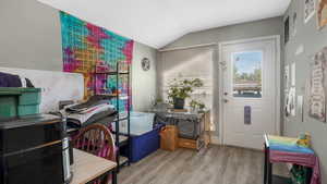 Entryway with lofted ceiling and light wood-style floors