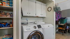 Laundry area with washing machine and dryer and light wood finished floors