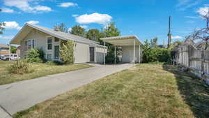 View of front facade with concrete driveway and an attached carport
