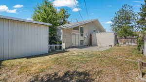 Rear view of property featuring a fenced backyard and a patio