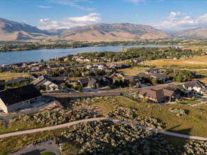 Aerial view of property and surrounding area featuring a water and mountain view and nearby suburban area