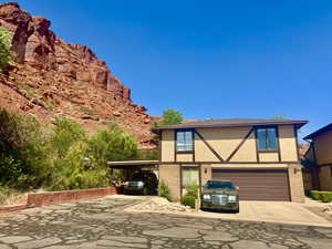 View of front facade with concrete driveway, stucco siding, a garage, brick siding, and a carport