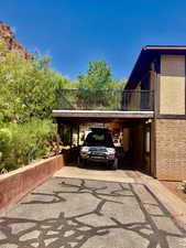 View of parking / parking lot with driveway and a carport
