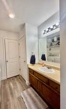 Bathroom with vanity, a textured ceiling, and wood finished floors
