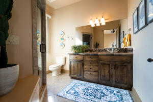 Bathroom with vanity, a shower with shower door, a chandelier, and tile patterned floors