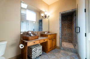 Bathroom with a chandelier, double vanity, and a shower stall