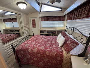 Carpeted bedroom featuring lofted ceiling