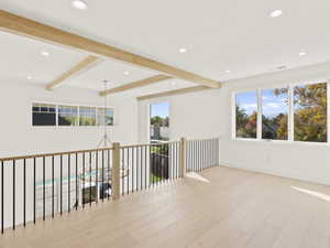 Corridor featuring beamed ceiling, recessed lighting, light wood-style flooring, and an upstairs landing