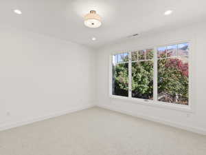 Carpeted spare room with baseboards and recessed lighting