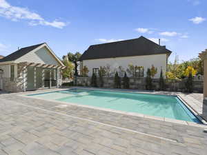 View of pool with a patio area and an outbuilding
