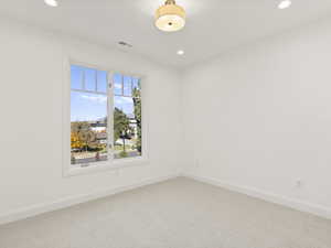 Carpeted empty room with baseboards and recessed lighting