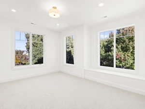 Unfurnished room with carpet, plenty of natural light, and recessed lighting