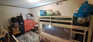 Bedroom featuring crown molding, a decorative wall, and carpet flooring