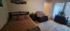 Bedroom featuring multiple windows and a decorative wall