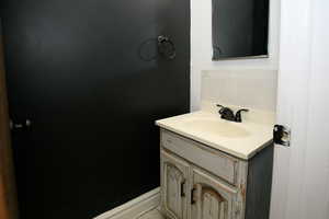 Bathroom featuring vanity and decorative backsplash