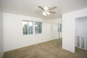 Unfurnished bedroom with carpet floors, a closet, and a ceiling fan