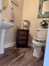 Half bathroom featuring wood finished floors and baseboards