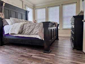 Bedroom featuring crown molding and dark wood-type flooring