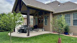 Rear view of house with french doors, a yard, roof with shingles, a patio area, and stucco siding