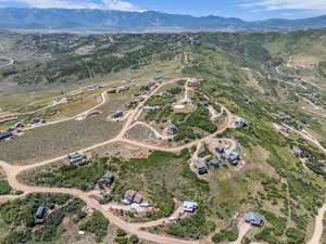 Aerial view of property and surrounding area featuring a mountain backdrop and rural landscape