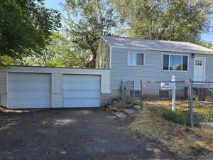 View of front of house featuring a garage and a shingled roof