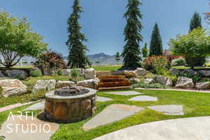 View of yard with an outdoor fire pit and a mountain view