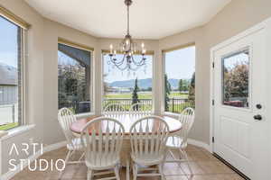 Dining area with light tile patterned floors, a chandelier, and a mountain view