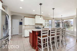 Kitchen with stainless steel appliances, arched walkways, light countertops, light tile patterned floors, and recessed lighting