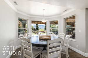Dining area featuring crown molding and dark stone finish flooring