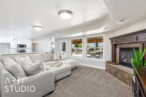 Carpeted living room featuring a tile fireplace and baseboards