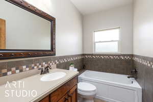 Full bathroom with a garden tub, vanity, and tile walls