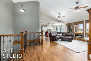 Living room featuring a ceiling fan, hardwood / wood-style flooring, and high vaulted ceiling