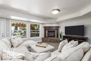 Carpeted living area featuring a premium fireplace and baseboards