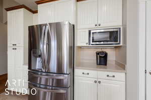 Kitchen featuring stainless steel appliances and white cabinetry