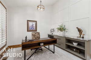 Office space with lofted ceiling, a chandelier, healthy amount of natural light, and light tile patterned floors