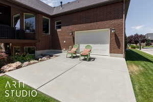 View of side of home with brick siding, concrete driveway, a garage, roof with shingles, and a lawn