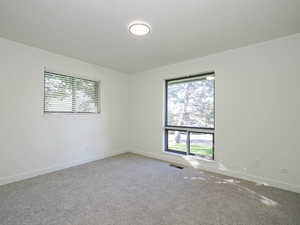 Carpeted empty room featuring plenty of natural light