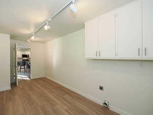 Spare room with rail lighting, wood finished floors, and a textured ceiling