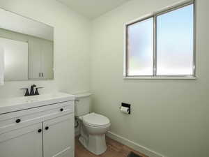 Half bathroom featuring wood finished floors and vanity