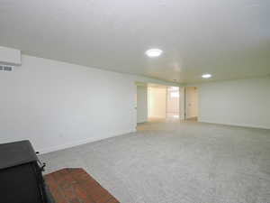 Unfurnished living room with light carpet, a textured ceiling, and recessed lighting