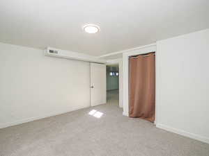 Unfurnished bedroom with a textured ceiling and light colored carpet