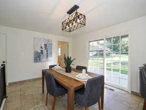 Dining area featuring baseboards and a chandelier