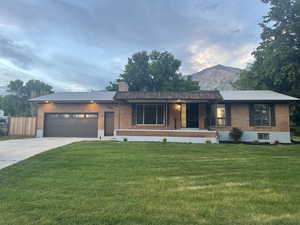 Single story home featuring covered porch, brick siding, and a front yard
